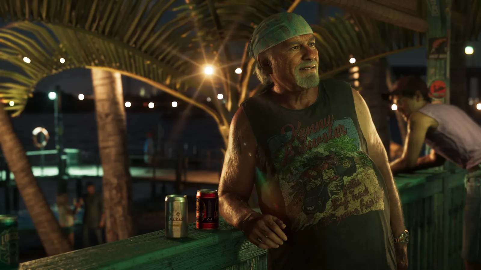 Brian Heder, in a bandana and a sleeveless T-shirt, leans on a waterside bar at night under palm trees and string lights