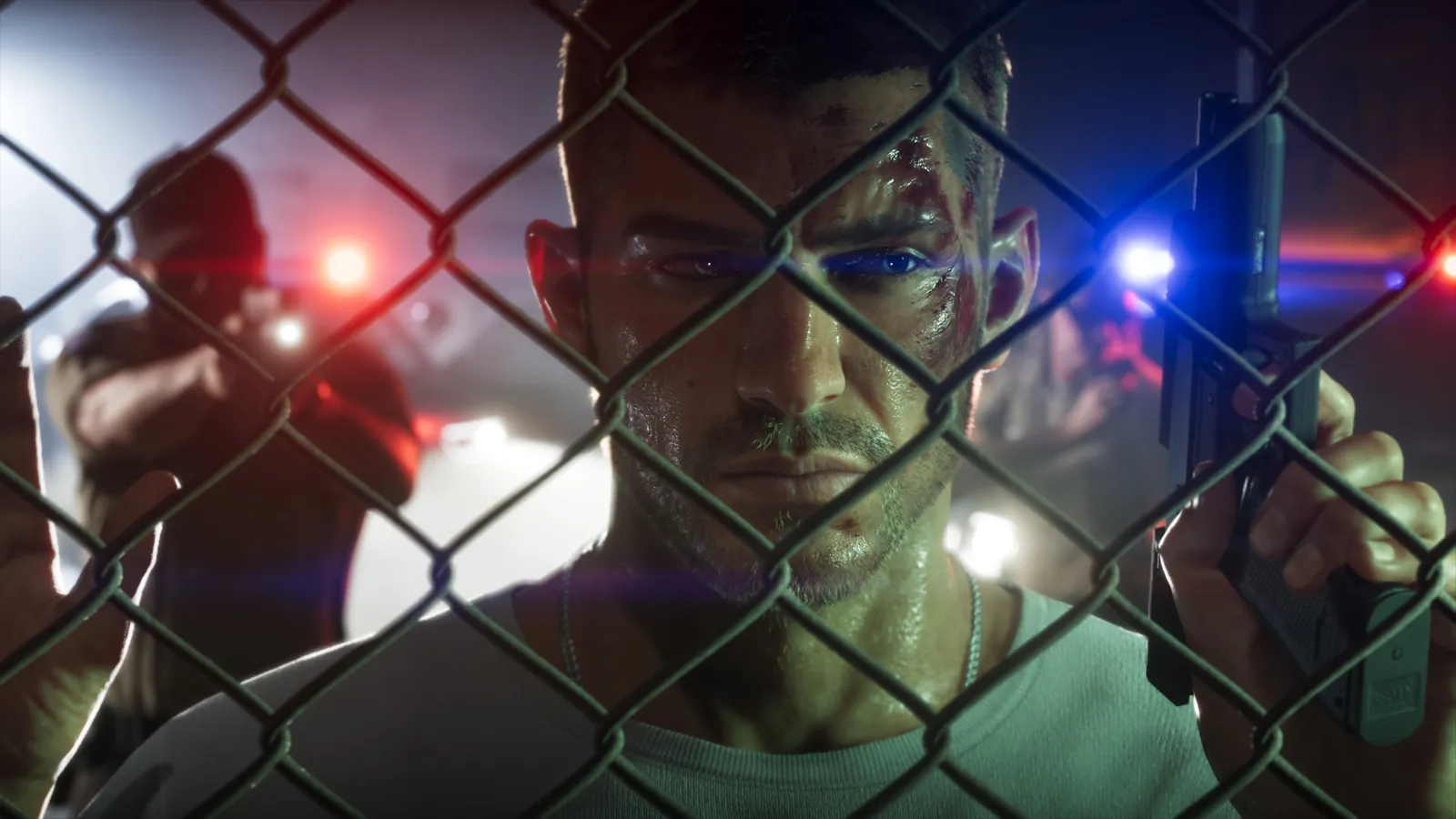 Jason, his face cut and sweaty, grips a pistol behind a chain-link fence while a police officer aims at him under red and blue lights