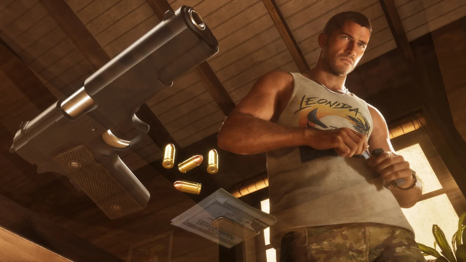 Jason in a tank top stands in a sunlit room with a pistol, ammunition and cash on the table in front of him