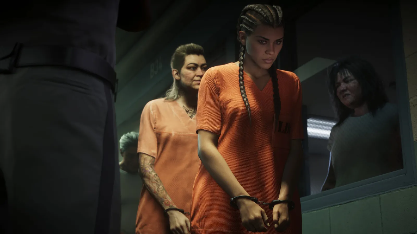 Lucia, in an orange jumpsuit and handcuffs, walks past a window behind another handcuffed inmate as a woman watches through the glass and an officer stands in the foreground