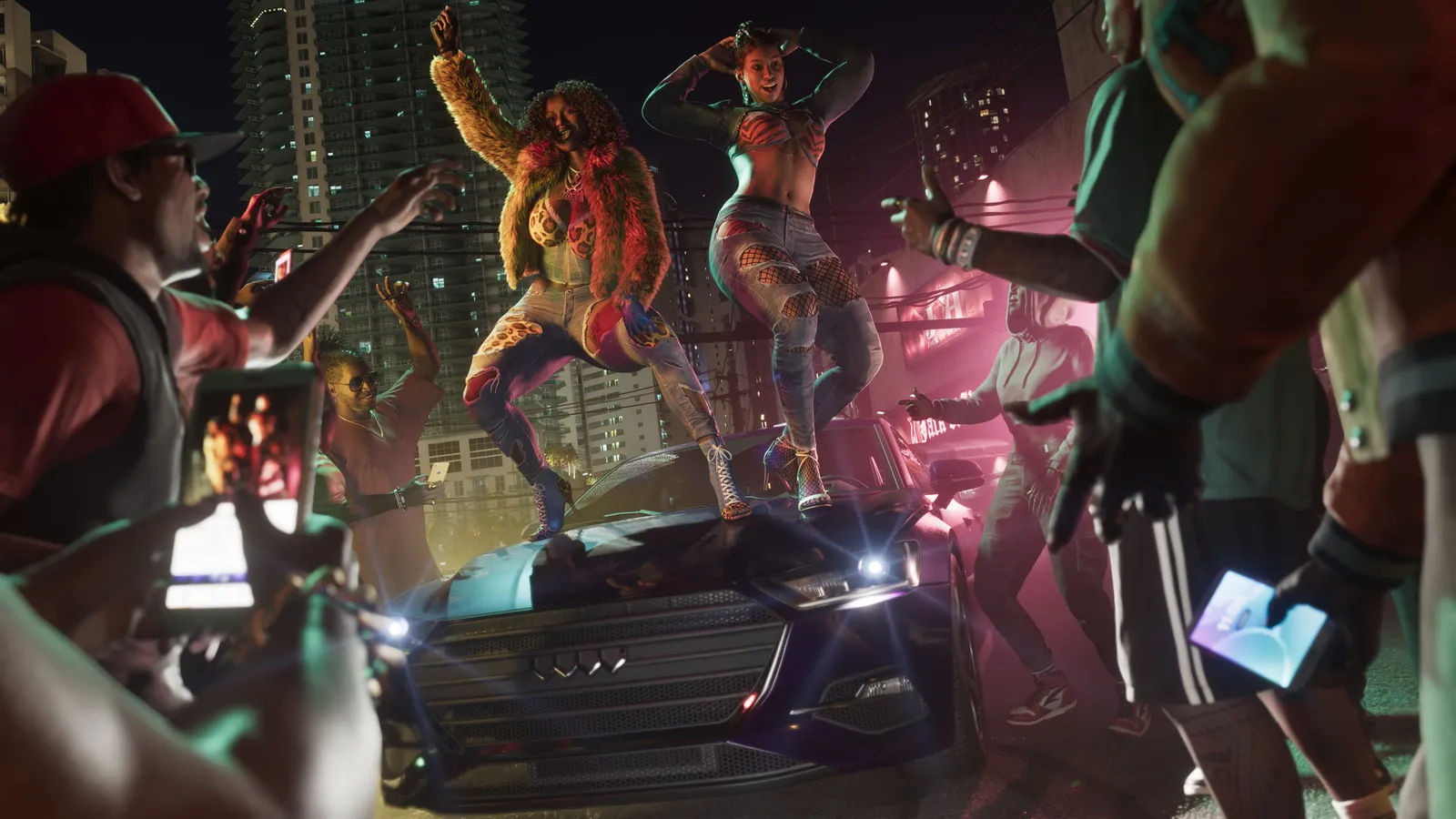 A crowd holding up phones to film Real Dimez as they dance on the hood of a car on a neon-lit street at night