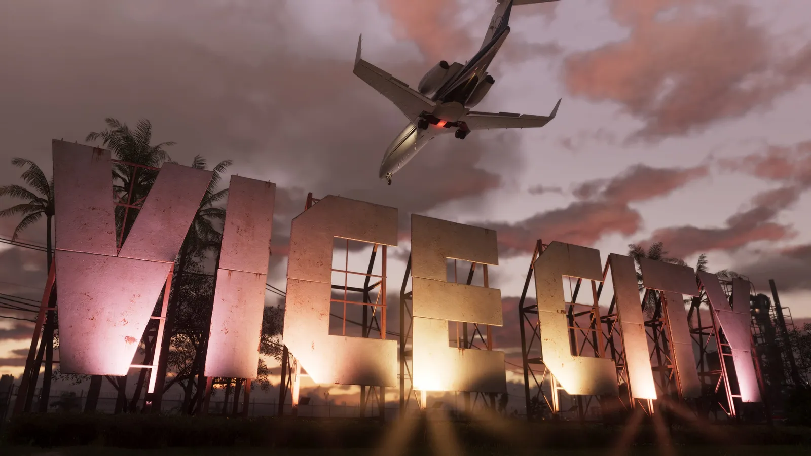 Giant floodlit Vice City letters at dusk as a jet passes low overhead with its landing gear down