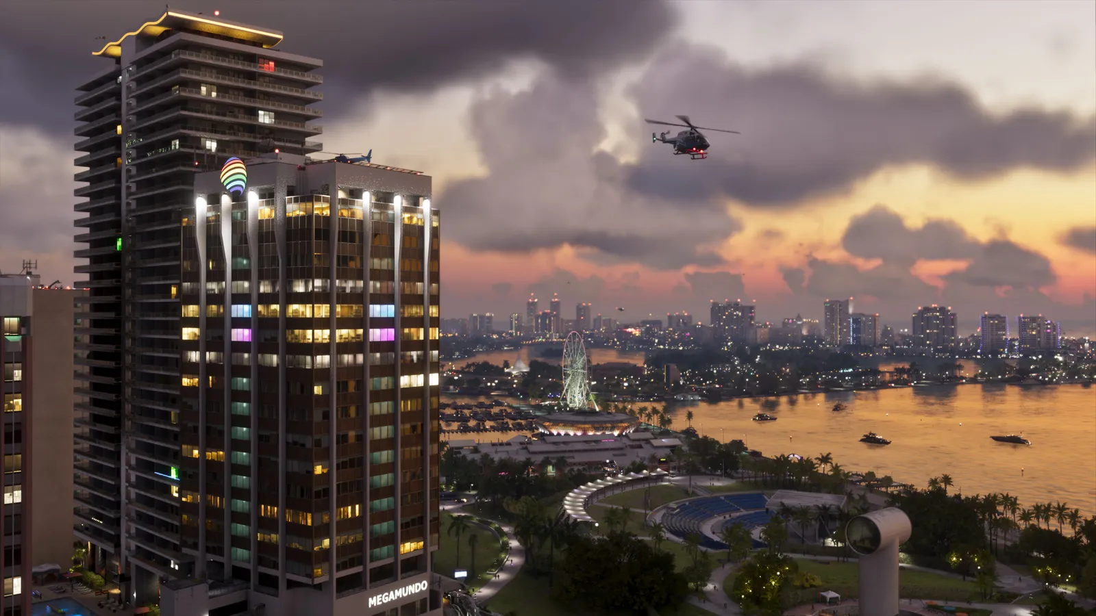 Vice City at dusk: a lit high-rise with a Megamundo sign, a helicopter over the bay, a Ferris wheel and boats on the water