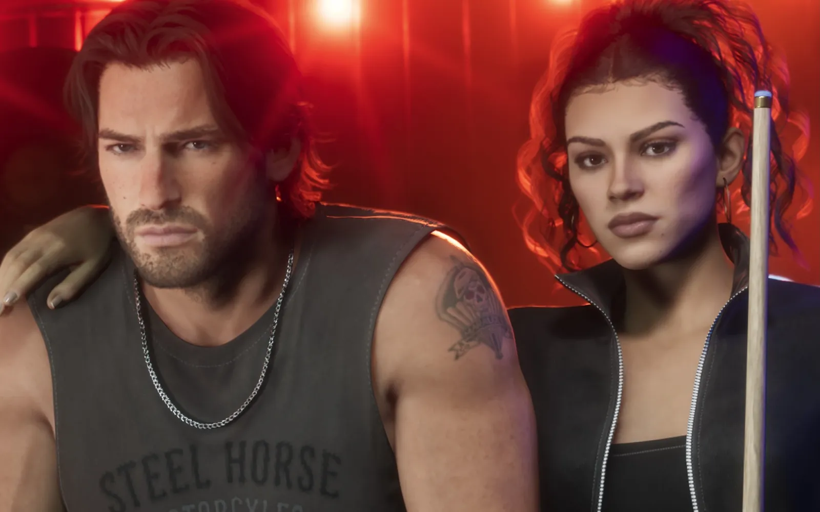 Jason, with long hair, a beard and a Steel Horse Motorcycles tank top, next to Lucia, who holds a pool cue under red bar lights